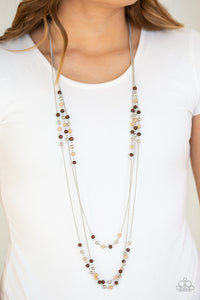 Dainty silver, brown, and wooden beads trickle along three shimmery silver chains, creating colorful layers across the chest. Features an adjustable clasp closure.  Sold as one individual necklace. Includes one pair of matching earrings.